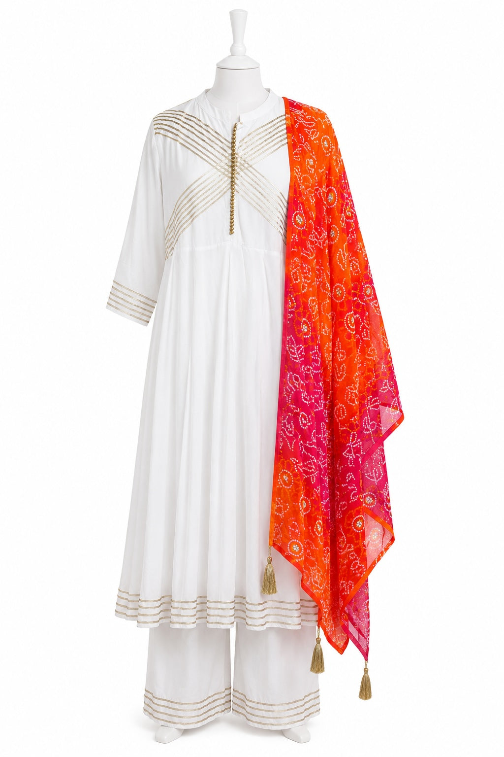 White traditional outfit with orange dupatta on a mannequin against a white background