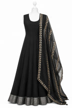 Black dress with gold embroidery on a mannequin against a white background