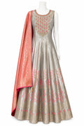 Traditional Indian outfit with a silver anarkali suit and pink dupatta on a white background