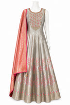 Traditional Indian outfit with a silver anarkali suit and pink dupatta on a white background