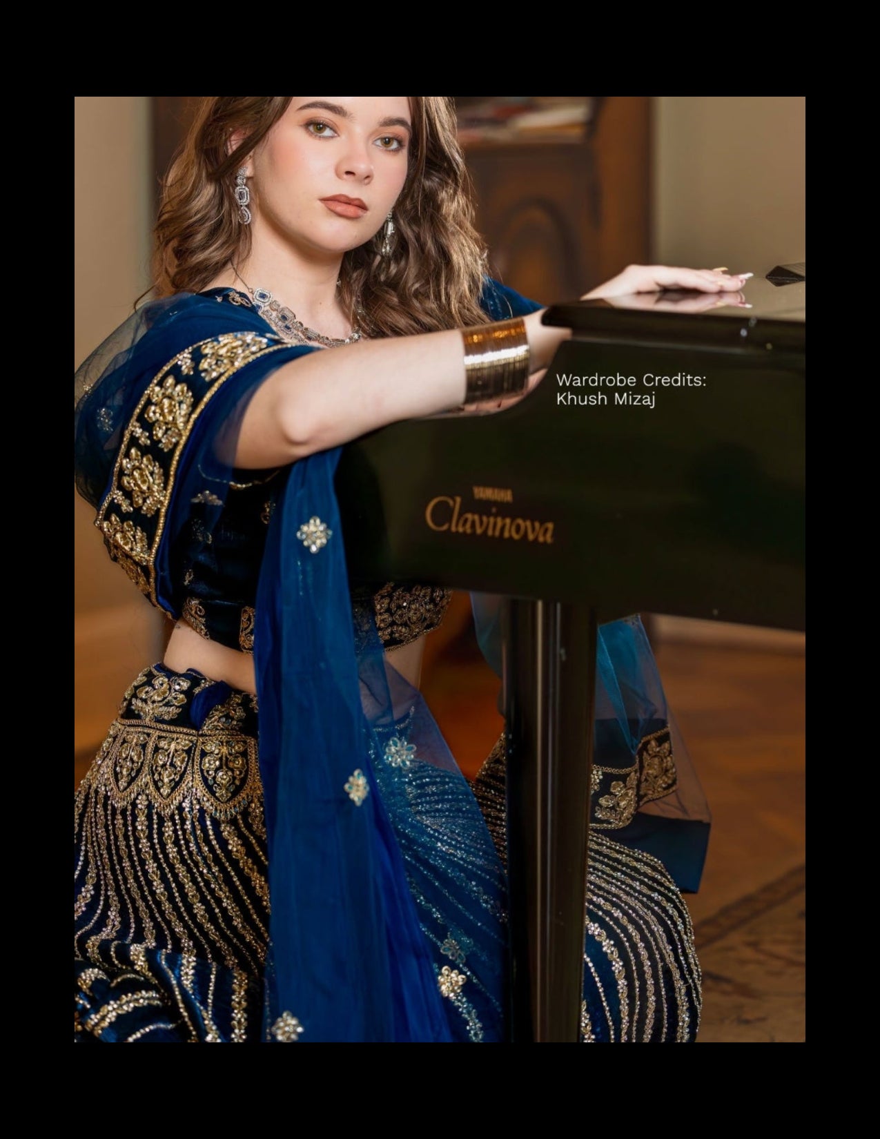 Woman in traditional blue and gold outfit holding a Clavinova piano