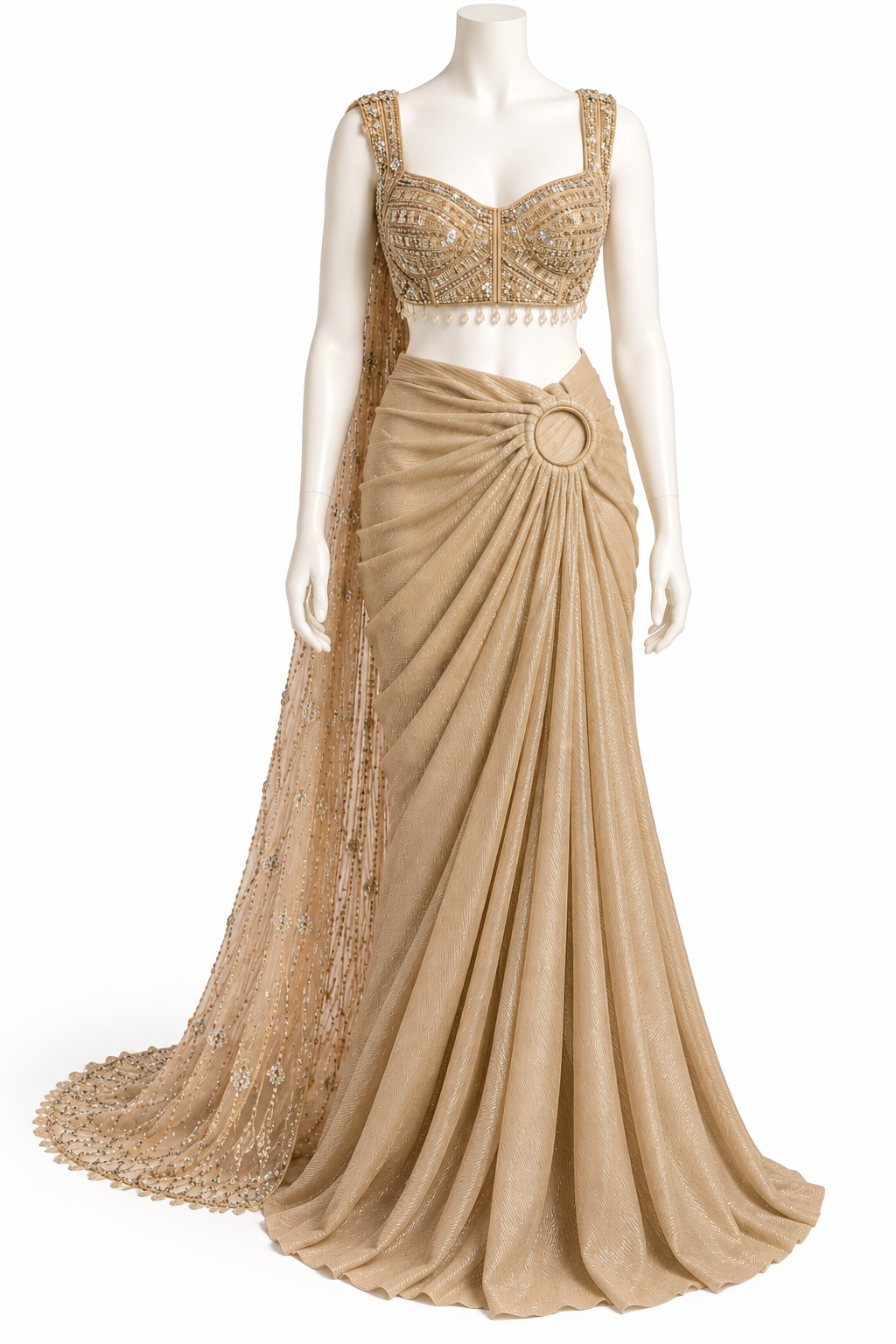 A beige and gold traditional Indian gown displayed on a white mannequin against a white background. The dress features a heavily embellished gold beaded crop top, a draped beige skirt with a circular waist detail, and a matching sheer embroidered dupatta.