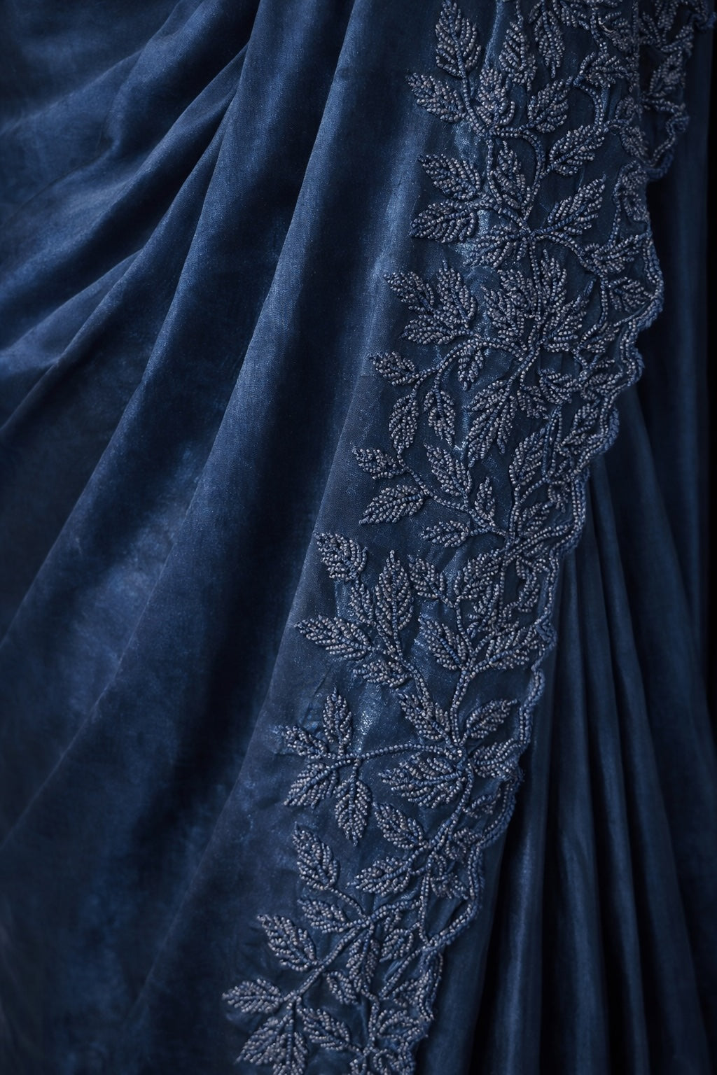 Navy blue fabric with intricate silver leaf embroidery
