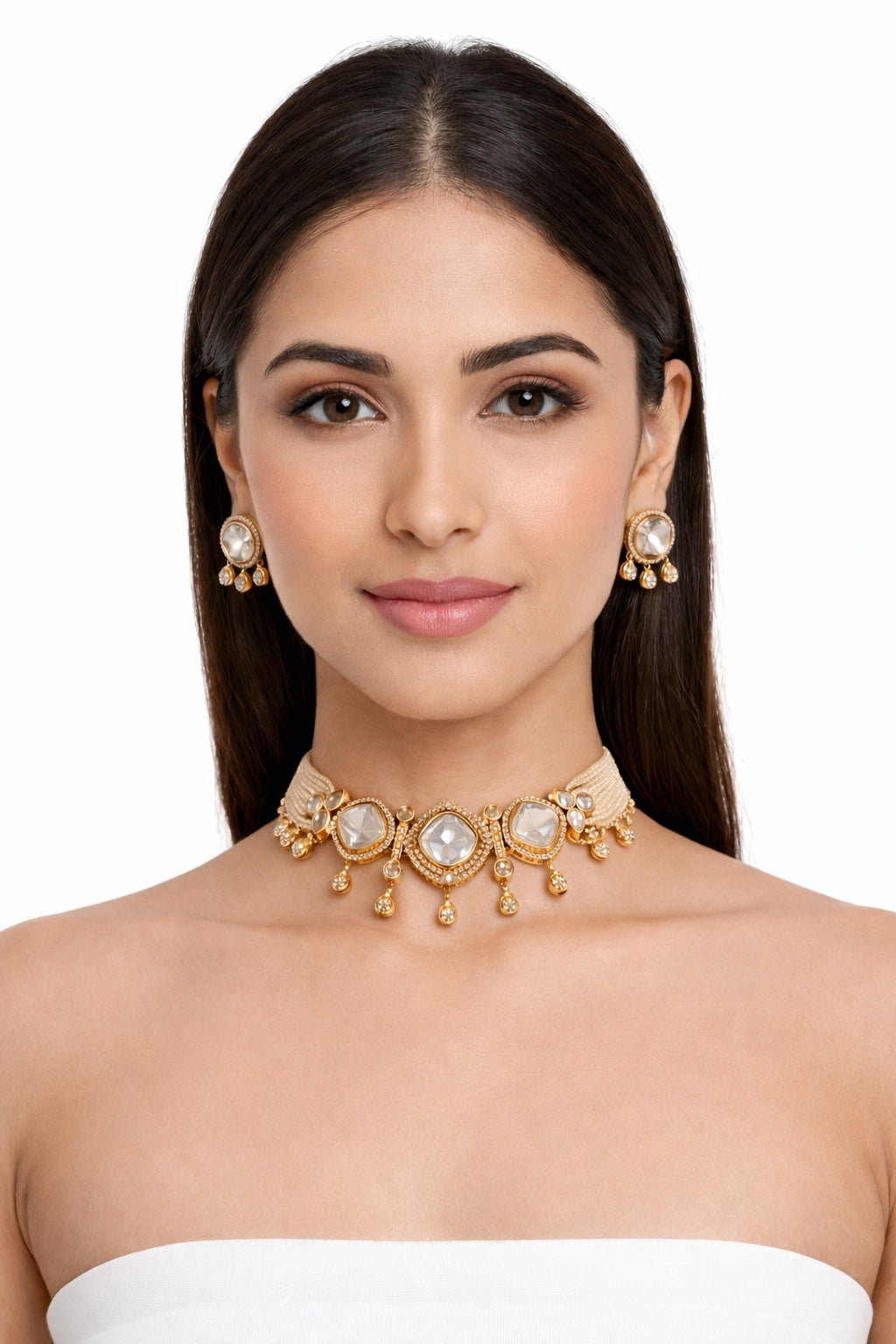 Woman wearing a gold necklace and earrings on a white background