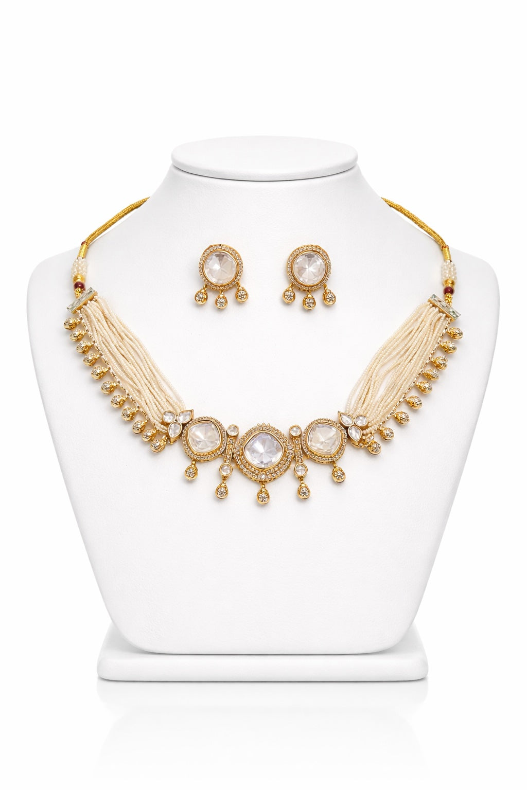 Gold necklace and earrings set on a white mannequin bust