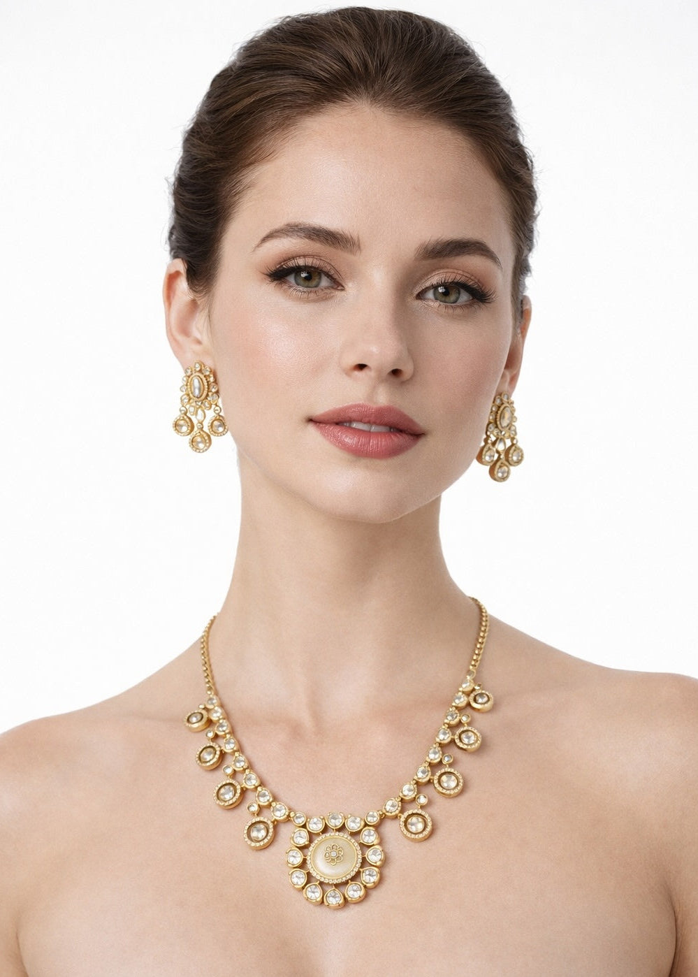 Woman wearing a gold necklace and earrings on a white background
