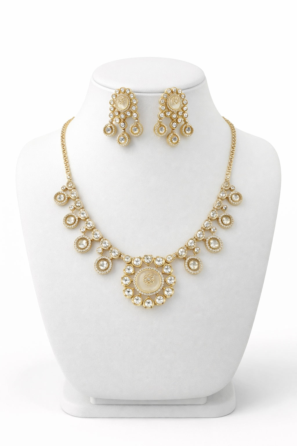 Gold necklace and earrings set on a white mannequin bust