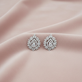 Pair of silver earrings on a pink fabric background