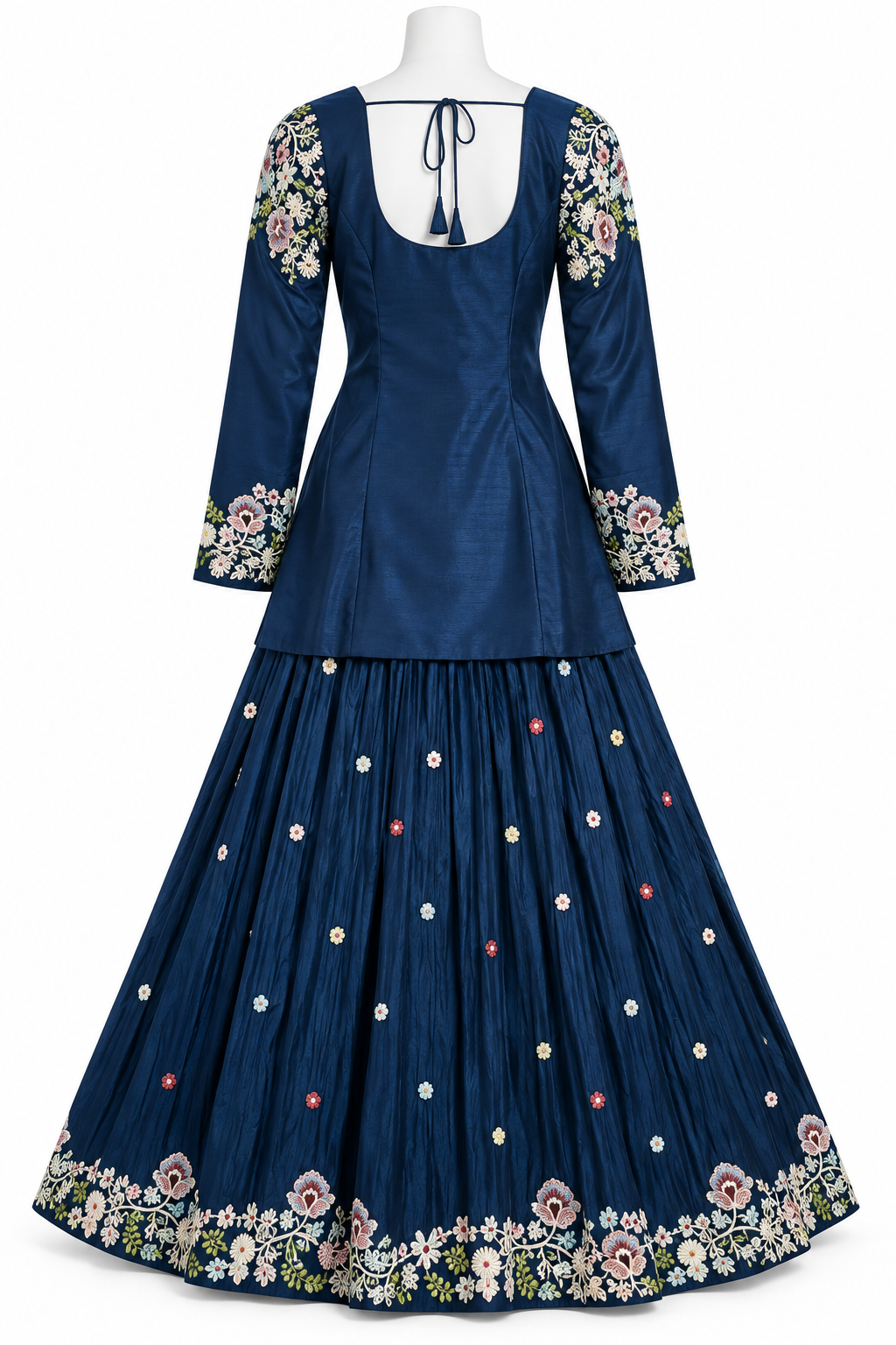 A navy blue traditional long dress displayed on a white mannequin against a white background. The dress features a fitted bodice with a tie-back neckline, three-quarter sleeves with floral embroidery at the cuffs, and a pleated skirt decorated with small colorful embroidered dots and a wide floral border at the hem.