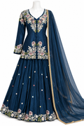 A navy blue traditional ethnic outfit displayed on a mannequin, featuring a heavily embroidered floral kurta with matching flared skirt and a sheer dupatta draped over one side.
