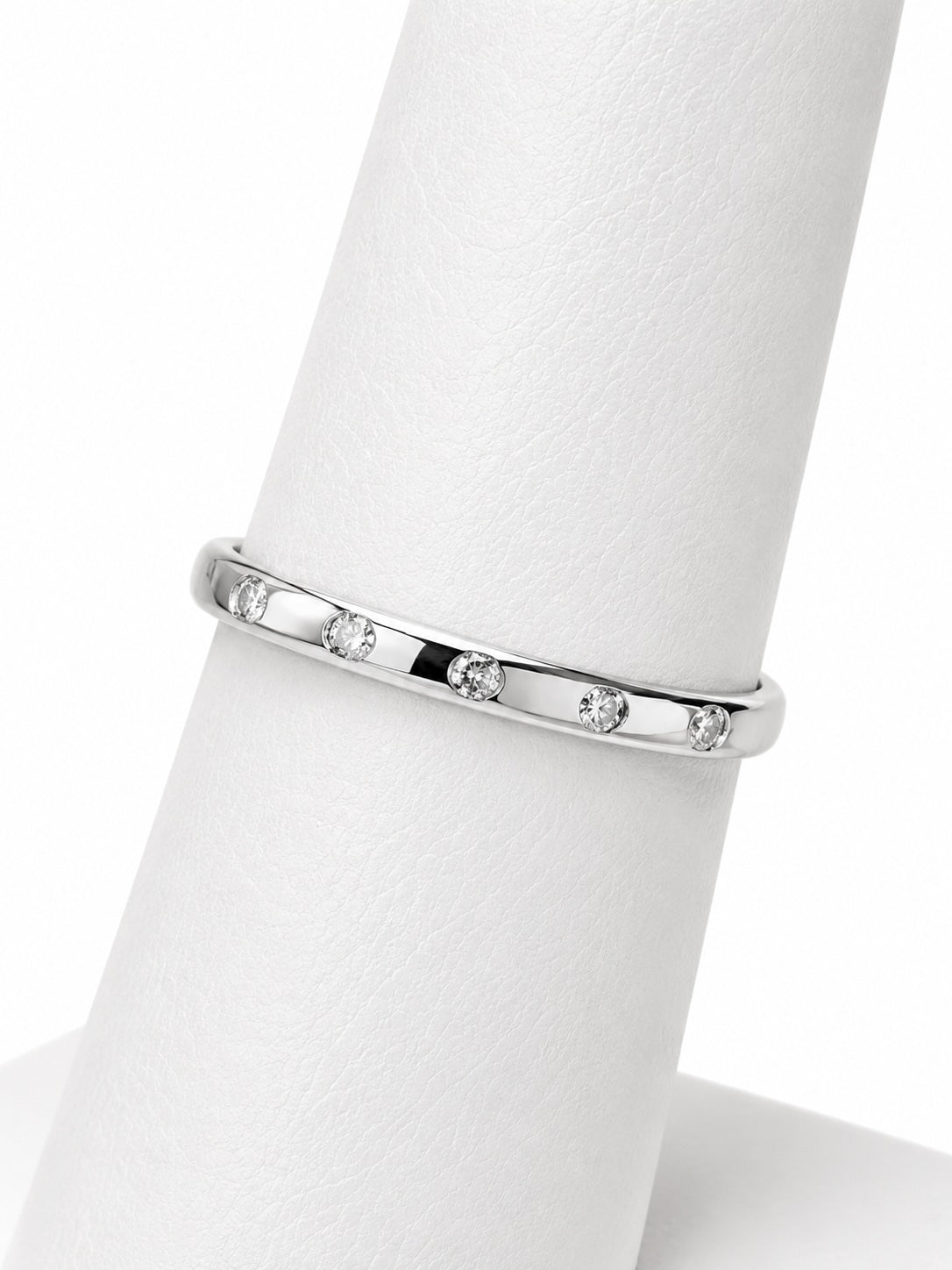 Silver ring with small diamonds on a white mannequin finger
