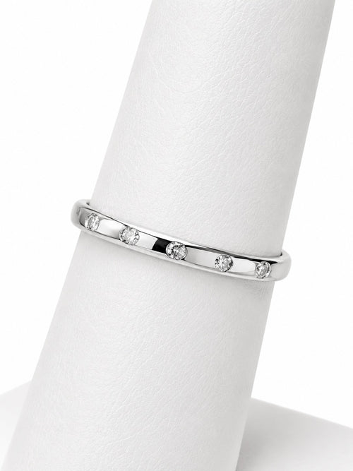 Silver ring with small diamonds on a white mannequin finger