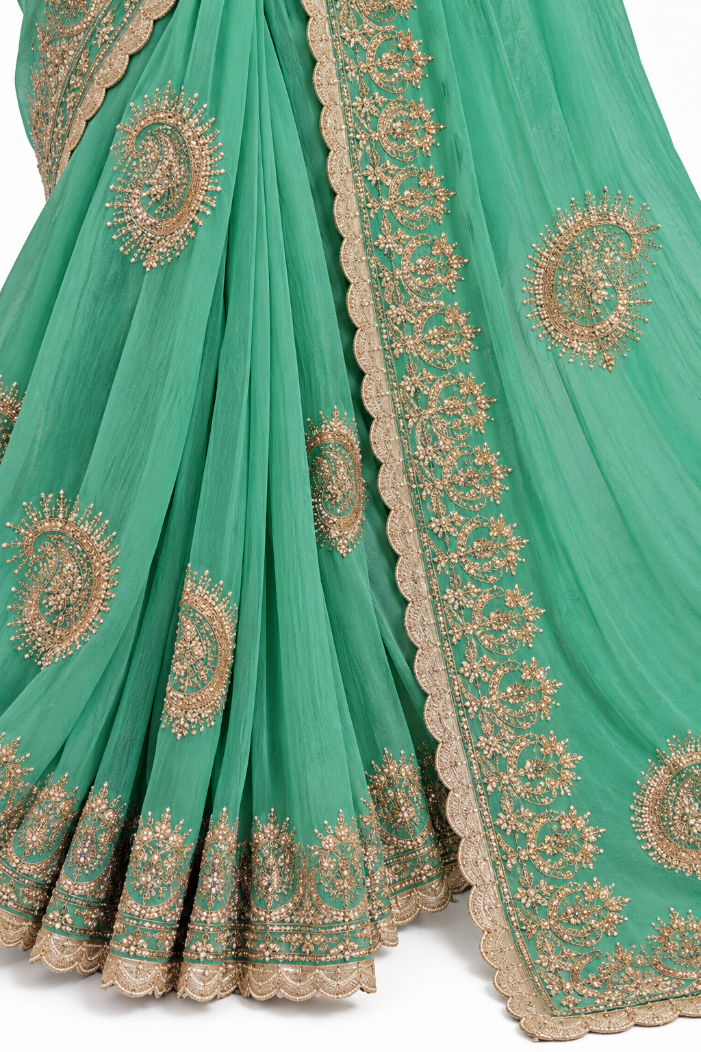 A close-up of a green georgette saree with detailed gold zari embroidery and a matching embroidered border, shown against a plain white background.