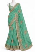 A mint green saree with gold floral embroidery and a scalloped border, displayed on a white mannequin against a plain white background.