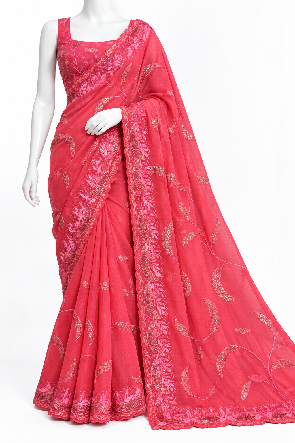 A bright pink georgette saree with metallic gold floral embroidery, displayed on a white mannequin against a plain white background.