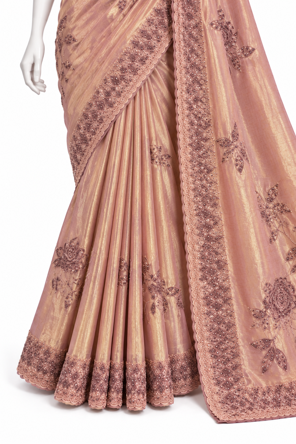 A peach-pink and gold pleated saree with dark brown floral embroidery and a matching embroidered border, displayed on a mannequin against a white background.