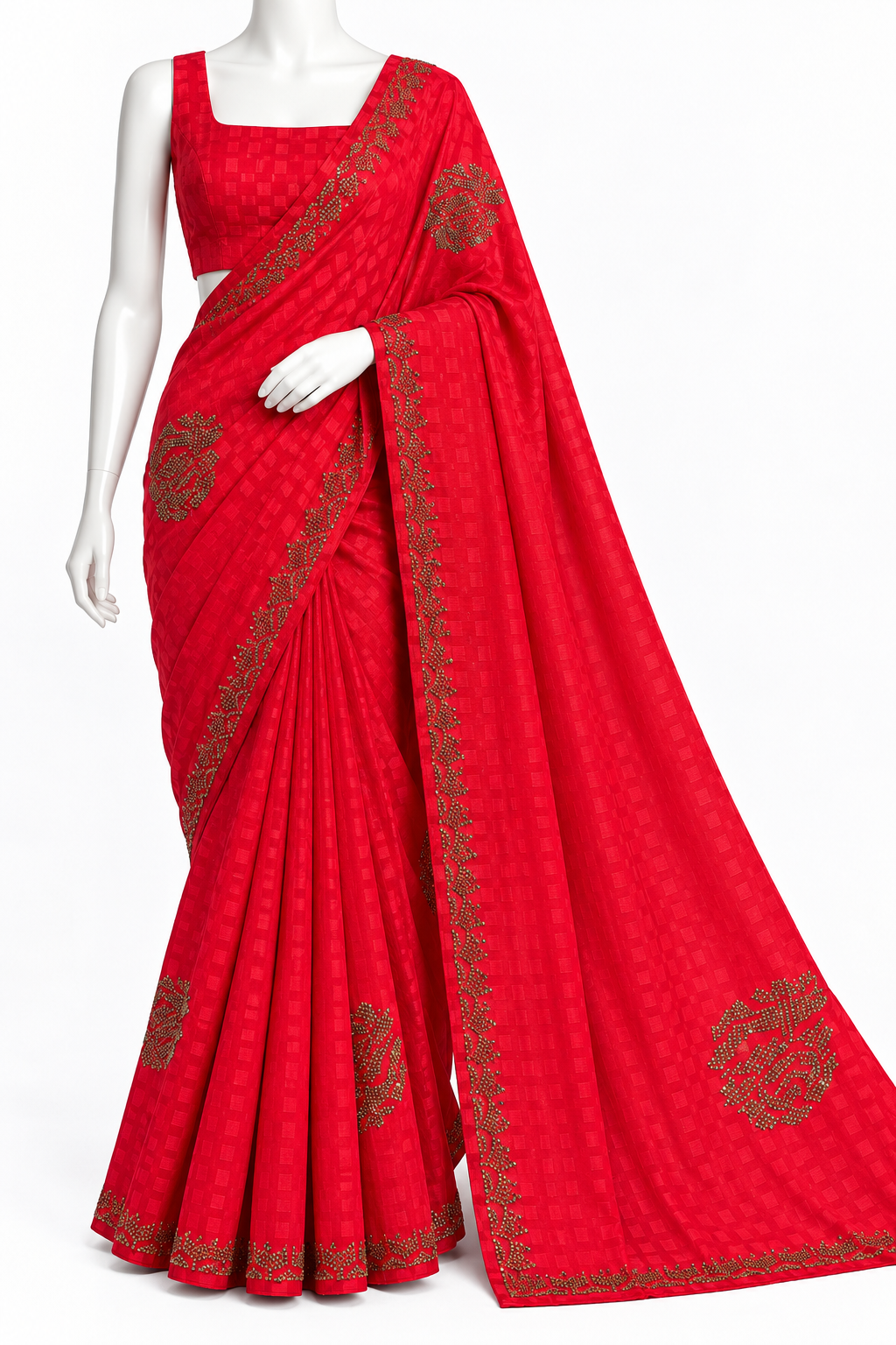 A bright red cotton saree with a matching sleeveless blouse, displayed on a white mannequin. The saree features a subtle woven pattern and detailed gold zari border and floral motifs.