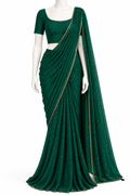 A dark green georgette saree with gold foil dot embellishments and a gold border, displayed on a white mannequin with a matching green short-sleeve blouse.