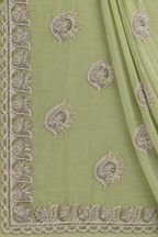 A sage green organza saree or fabric panel with intricate silver and white embroidery, featuring a decorative border and matching embroidered motifs.