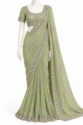 A sage green georgette saree with silver and gold floral embroidery, displayed on a white mannequin. The saree features a matching embroidered short-sleeve blouse.