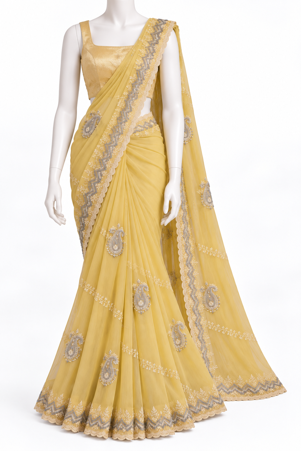 A yellow saree with gray and gold embroidered motifs and borders, displayed on a white mannequin with a matching yellow blouse against a white background.