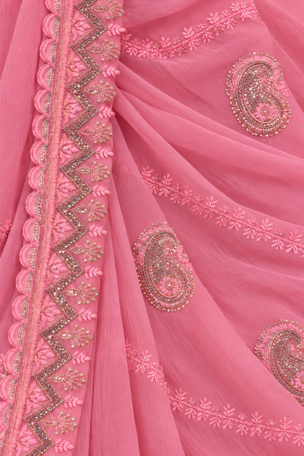 A close-up of a pink draped fabric, likely a saree or dupatta, featuring detailed paisley and floral embroidery with metallic gold and silver thread work.