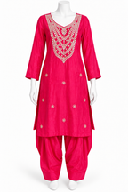 A bright pink Indian ethnic suit set displayed on a white mannequin, featuring a long kurta with intricate silver and gold embroidery around the neckline and scattered motifs on the front, paired with matching flared pants.