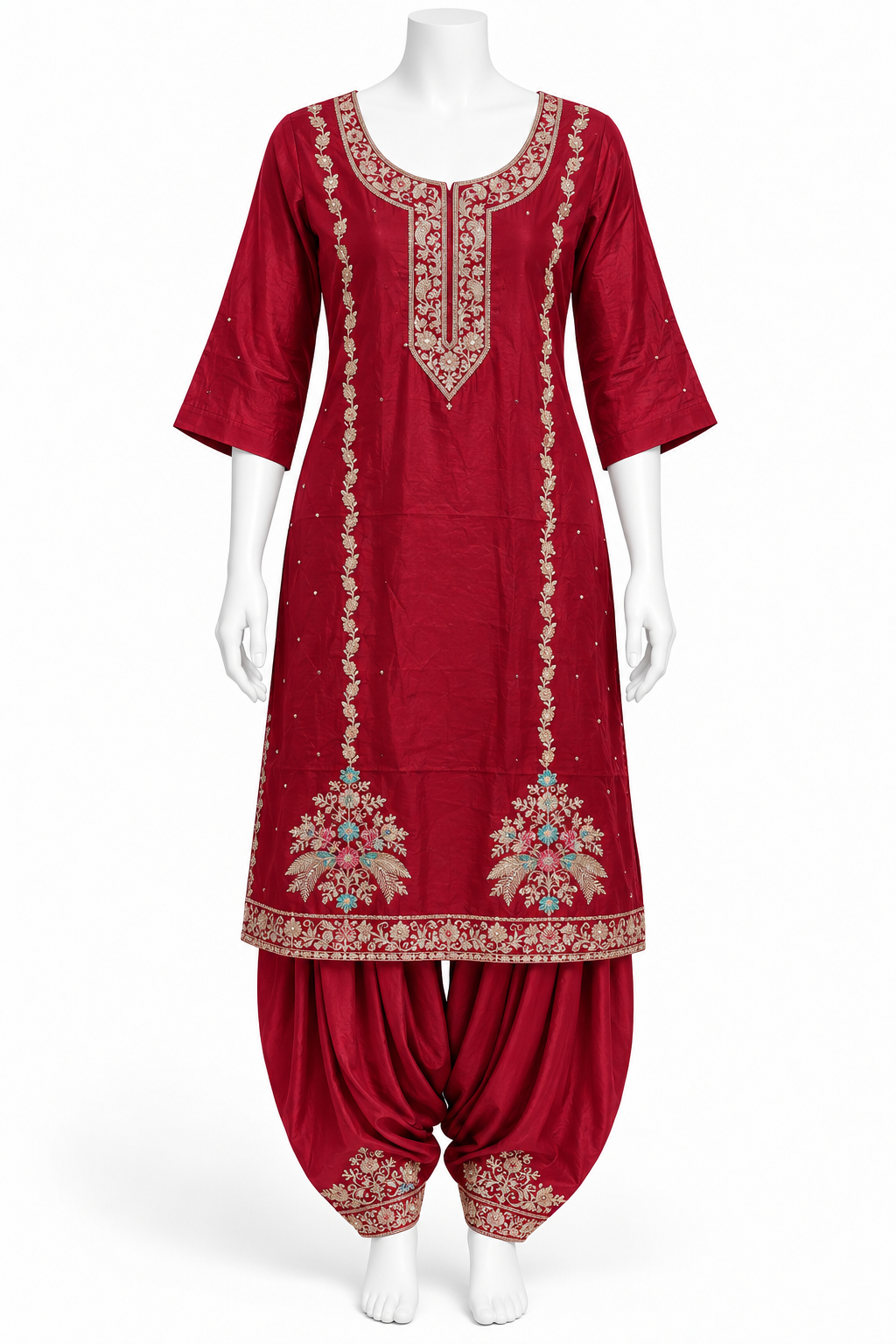 A red Indian ethnic suit set displayed on a white mannequin, featuring a kurta with gold and multicolor embroidery and matching patola pants.