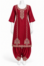 A red Indian ethnic suit set displayed on a white mannequin, featuring a kurta with gold and multicolor embroidery and matching patola pants.