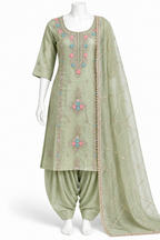 A sage green Indian ethnic suit set displayed on a white mannequin, featuring a kurta with colorful floral embroidery, matching pants, and a sheer dupatta.