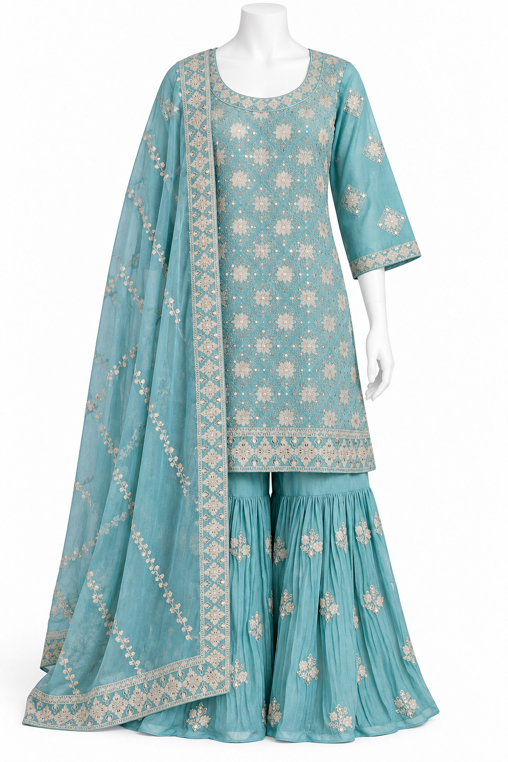 A three-piece traditional outfit displayed on a white mannequin, featuring a turquoise blue kurta and flared sharara pants with beige floral embroidery, accompanied by a matching sheer dupatta.