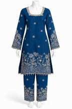 A blue traditional kurta and trouser set displayed on a white mannequin against a plain white background. The outfit features intricate gold floral embroidery concentrated around the neckline, sleeve cuffs, hem, and pant legs.