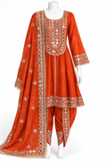 An orange traditional Indian salwar kameez suit set with intricate silver, white, and black embroidery, displayed on a white mannequin against a white background.