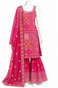 A bright pink traditional Indian outfit displayed on a white mannequin, featuring a heavily embroidered kurta, matching flared pants, and a sheer embroidered dupatta.