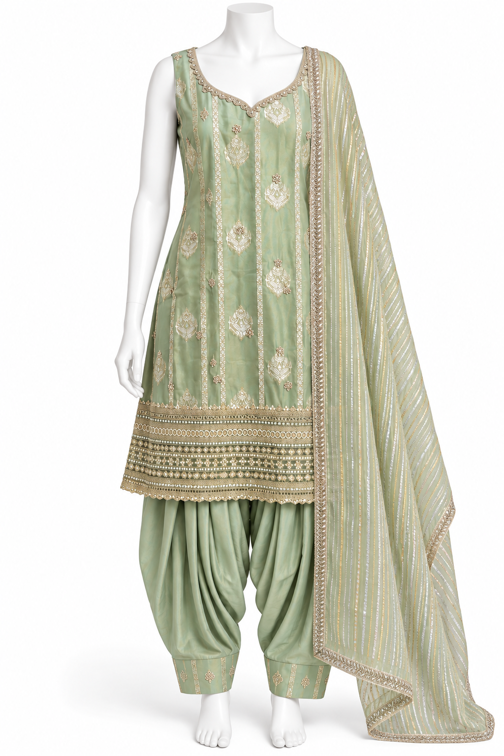 A sage green traditional Indian outfit displayed on a white mannequin, featuring a sleeveless embroidered kurta, matching patola-style pants, and a striped dupatta with gold borders.