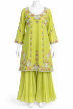 A lime green three-piece salwar kameez suit set displayed on a white mannequin. The set includes a long-sleeved embroidered kameez top, matching wide-leg trousers, and a coordinating waist scarf.