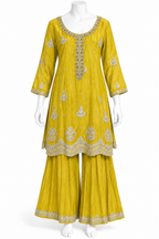 A yellow three-piece traditional Indian outfit displayed on a white mannequin, featuring a kurta with silver embroidery, matching pleated pants, and a coordinating belt.
