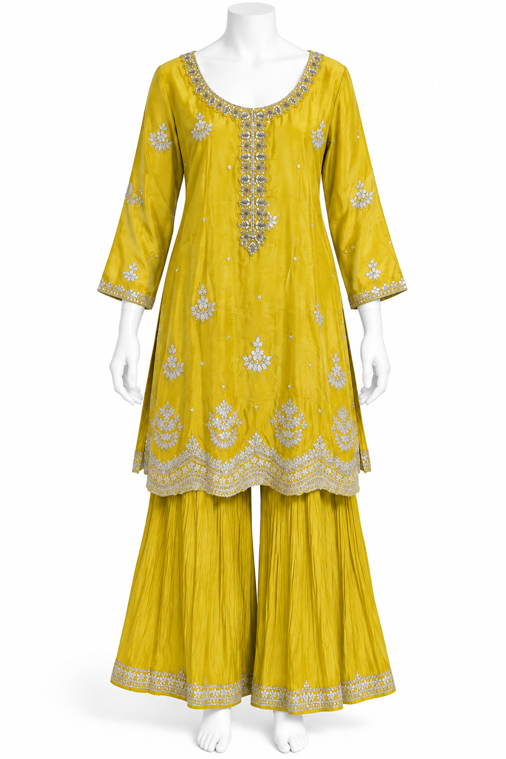 A yellow three-piece traditional Indian outfit displayed on a white mannequin, featuring a kurta with silver embroidery, matching pleated pants, and a coordinating belt.