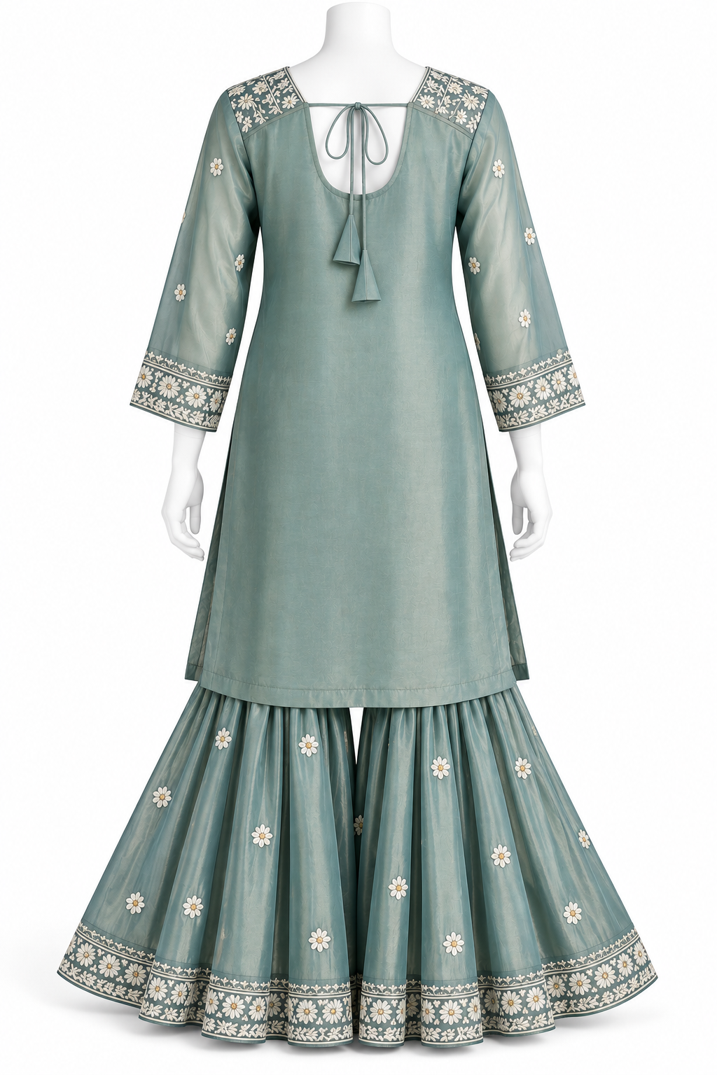 A sage green three-piece traditional Indian outfit displayed on a white mannequin, featuring a long kurta with a tie-neck and tassel, flared sharara pants, and matching embroidered pants.