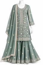 A three-piece traditional Indian outfit displayed on a white mannequin against a white background. The set includes a sage green embroidered kurta, matching flared pants, and a coordinating dupatta.