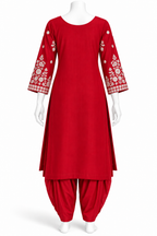 A red traditional kurta set displayed on a white mannequin, featuring a long red kurta with white floral embroidery on the three-quarter sleeves and matching red patina pants.