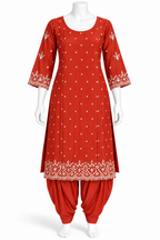 A red salwar kameez suit set displayed on a white mannequin, featuring a kurta with white embroidered patterns and a matching red patola pant.