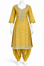 A mustard yellow traditional Indian outfit displayed on a white mannequin, featuring a kurta with silver mirror-work embroidery and matching harem pants.