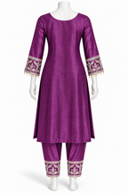 A purple three-piece kurta set with matching pants displayed on a white mannequin. The kurta has three-quarter sleeves with ornate gold and white embroidery and tassel trim at the cuffs, and matching embroidered trouser cuffs.