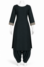 A black three-piece traditional outfit displayed on a white mannequin, featuring a straight kurta with gold and silver embroidered sleeve cuffs, matching black pants, and black draped fabric.