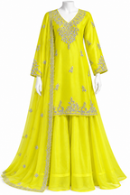 A bright yellow traditional Indian outfit displayed on a white mannequin, featuring a long kurta with silver embroidery, matching flared pants, and a sheer dupatta draped over one shoulder.