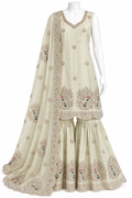 A traditional Indian salwar kameez suit displayed on a white mannequin. The set features an off-white/cream kurta and matching flared pants (sharara) with intricate gold embroidery, scalloped borders, and peacock motifs, accompanied by a matching sheer dupatta.