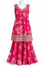 A sleeveless magenta pink traditional dress with a floral print and ornate gold embroidery, displayed on a white mannequin against a white background.