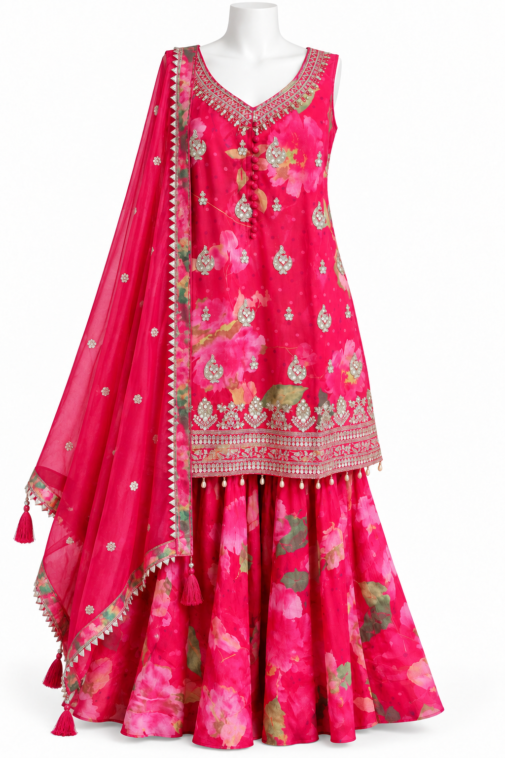A bright pink floral traditional outfit displayed on a white mannequin against a plain white background. The set includes a sleeveless embroidered top, matching flared skirt, and a sheer dupatta with decorative borders and tassels.