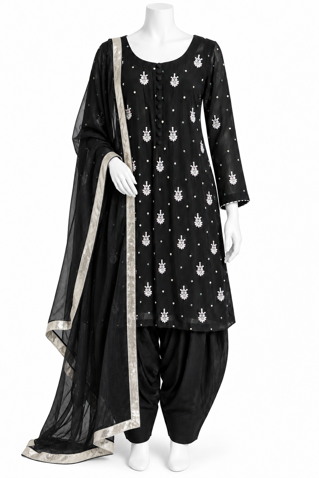 A black three-piece traditional outfit displayed on a white mannequin, featuring a kurta with white motifs, black patola pants, and a matching black dupatta with a silver border.